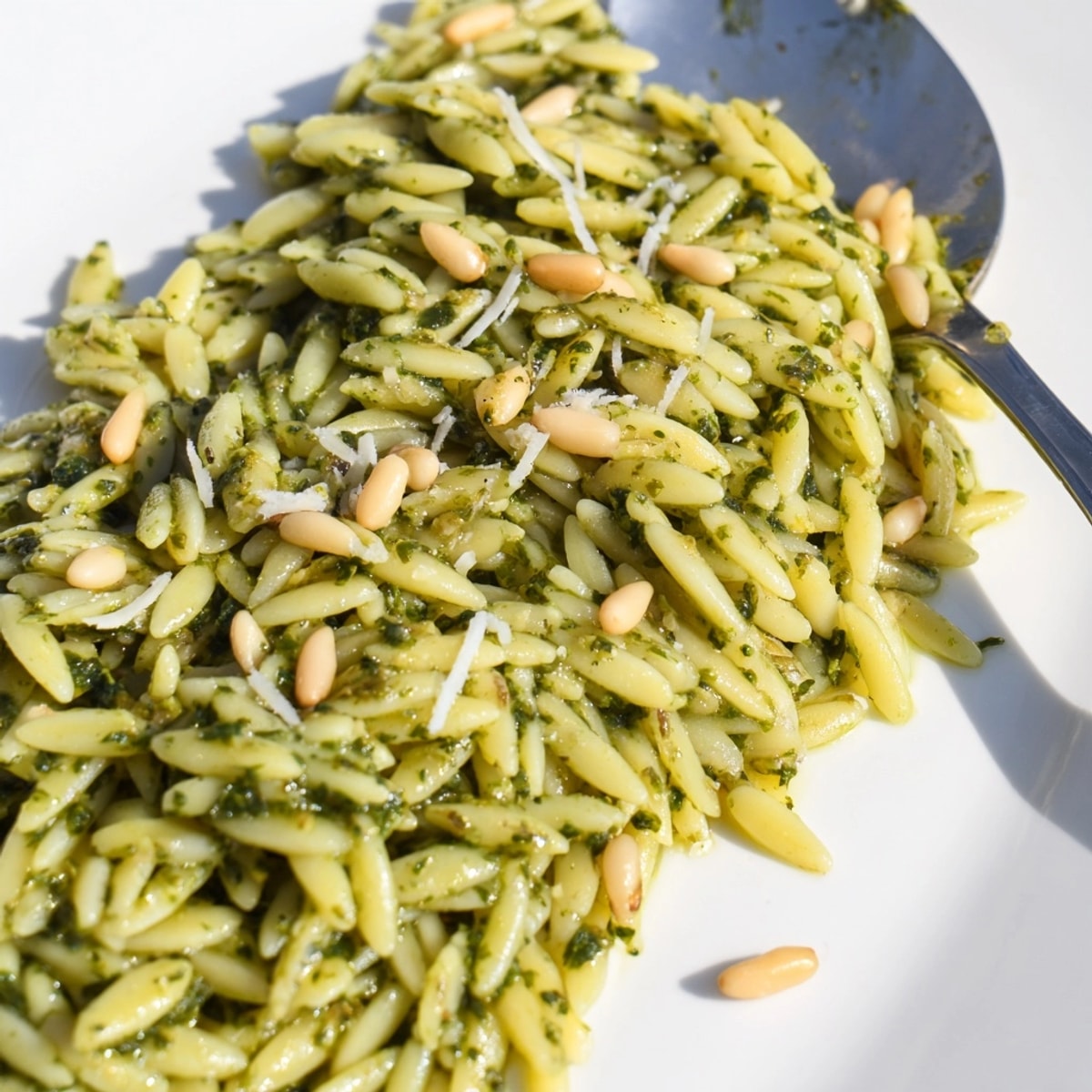 Close-up of perfectly cooked Spinach Pesto Orzo with a sprinkle of parmesan, Italian-inspired.