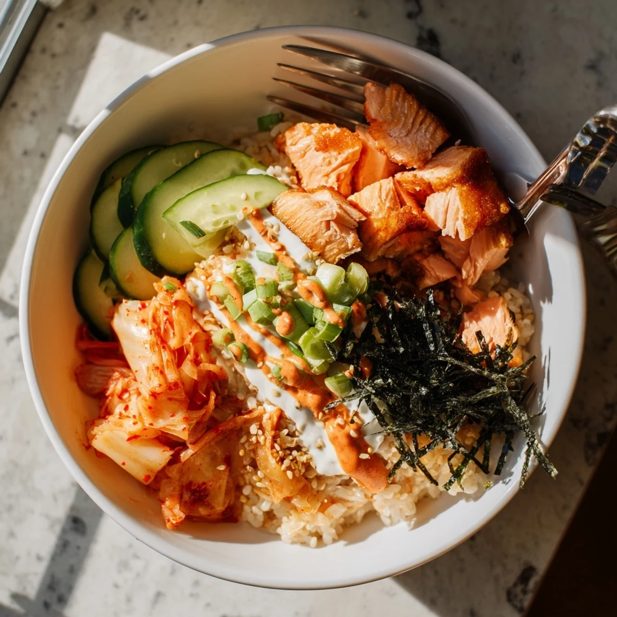 Crispy Salmon Rice Bowl topped with spicy mayo, fresh avocado, and tangy kimchi.  