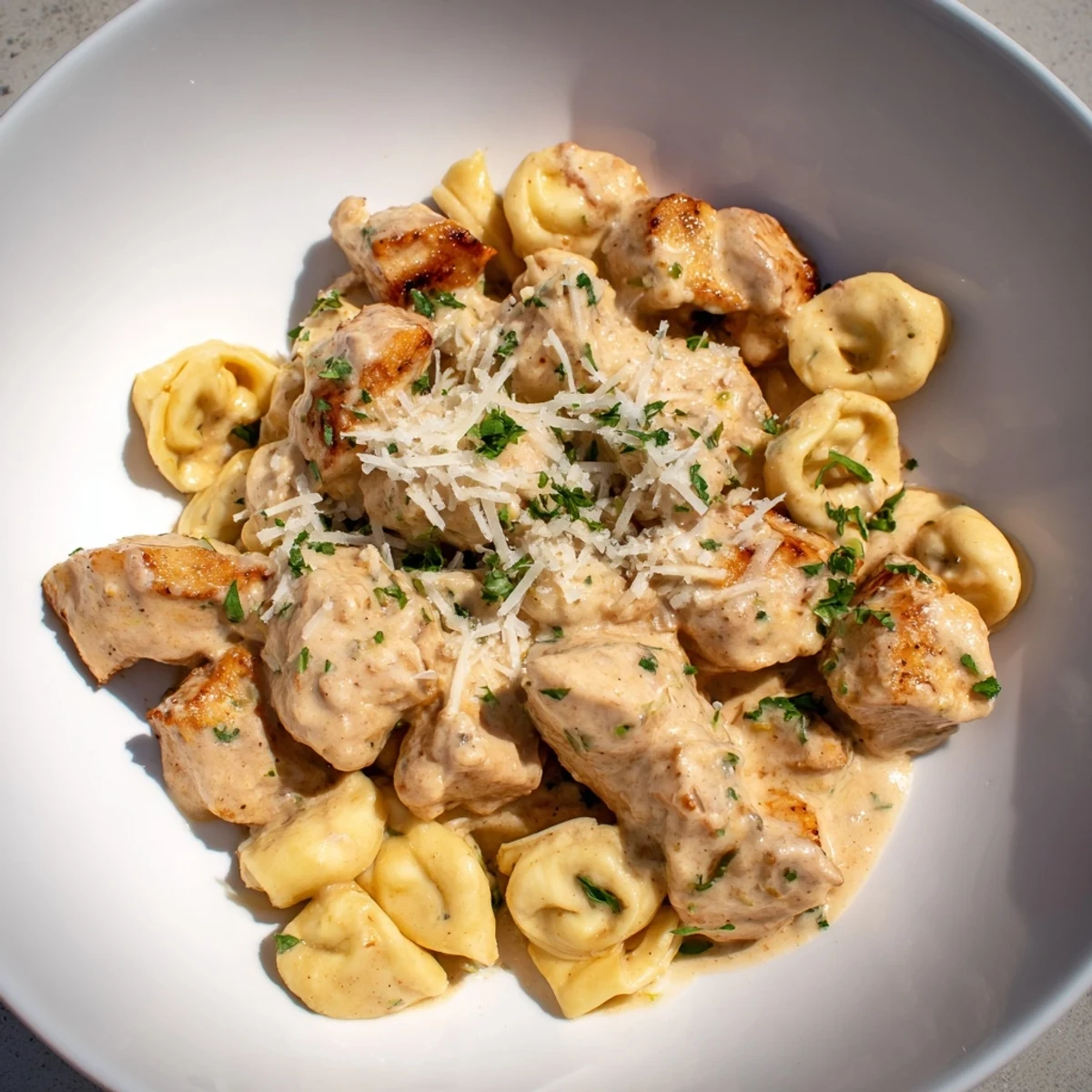 A pan filled with Zesty Cajun Garlic Parmesan Chicken Tortellini, showcasing the creamy, cheesy sauce over pasta.