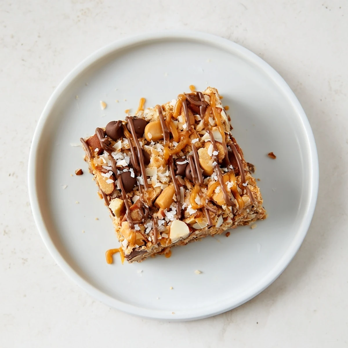 Chewy, decadent squares of 7-Layer Magic Bars, drizzled with sweet caramel and flaky sea salt.