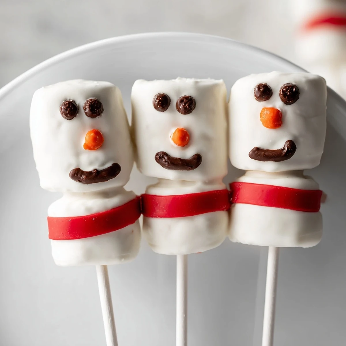 Express Snowman Marshmallow Pops dipped in glistening white chocolate, ready for a winter treat.