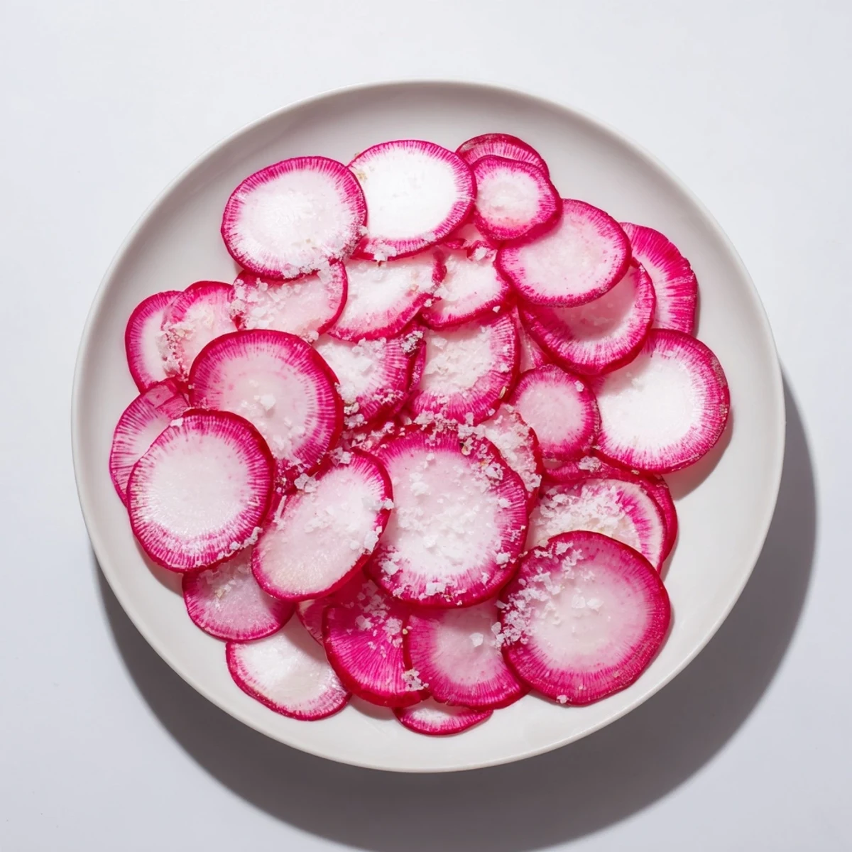 Crisp radish slices glistening with sea salt, ready to eat as an easy, healthy snack.
