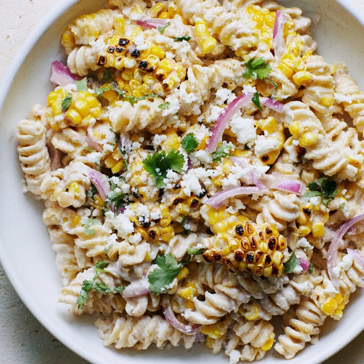 Creamy street corn pasta salad, a colorful dish with sweet corn and crumbled cotija, tastes fantastic.