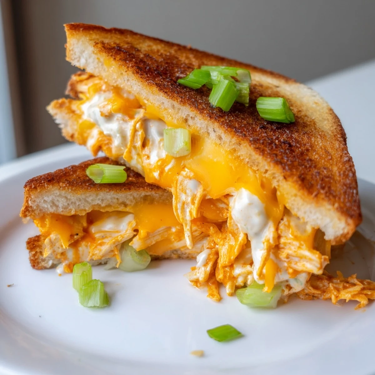 Freshly grilled Buffalo Chicken Ranch Grilled Cheese sandwich with melted cheddar and shredded chicken on golden buttery sourdough.