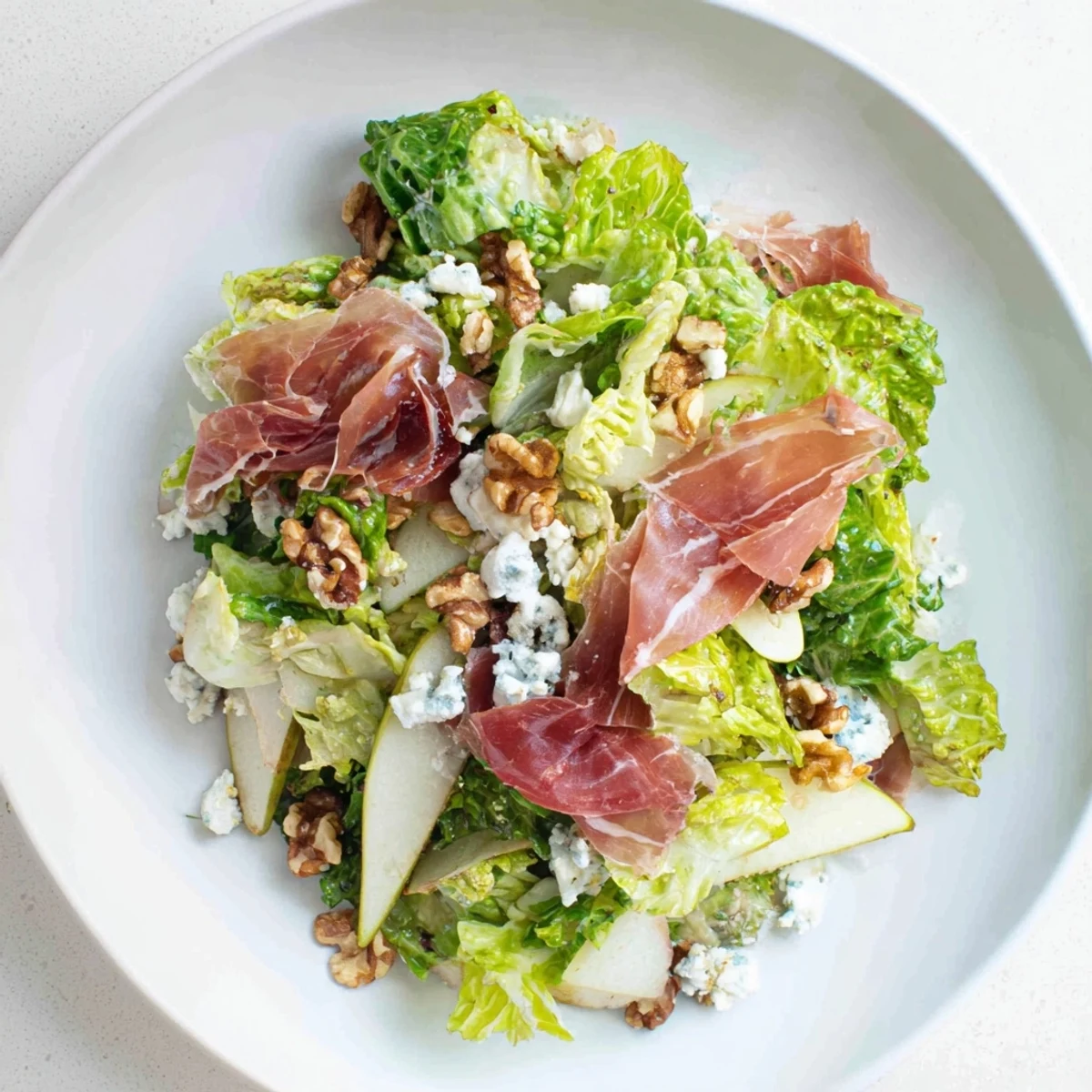 Frisée Pear Blue Cheese Salad with crispy prosciutto, a vibrant lunch delight.