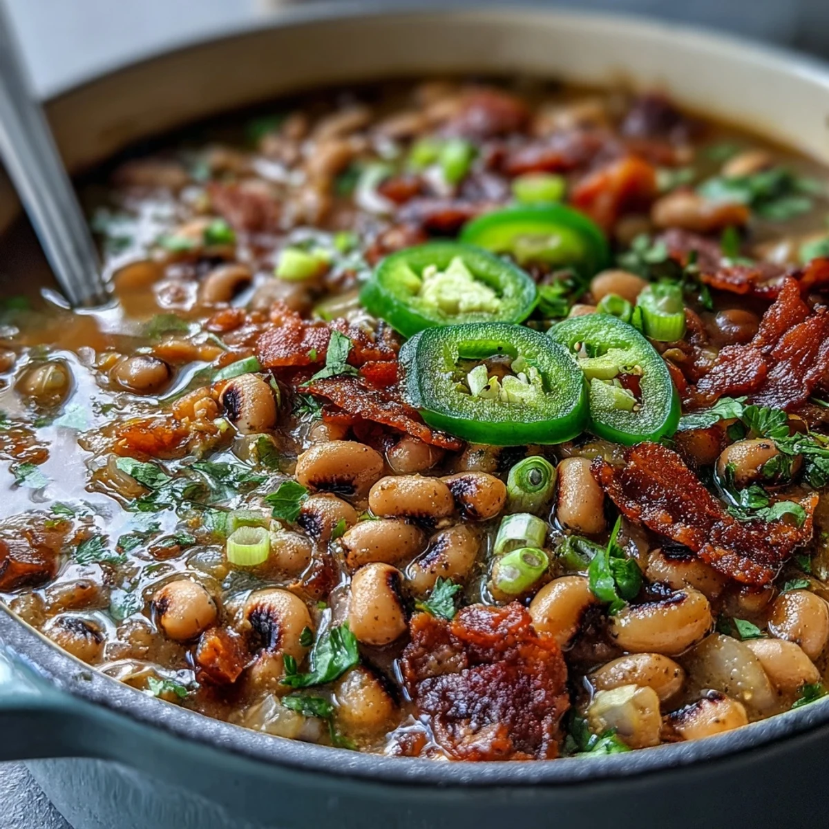 Big Pot of Texas Black-Eyed Peas simmering in a Dutch oven with a rich, smoky tomato broth and bay leaves.