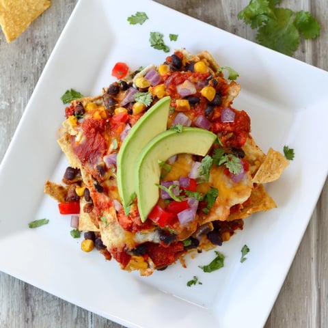 Quick Black Bean and Corn Tortilla Casserole bubbling with melted cheese and ready to serve with fresh cilantro.