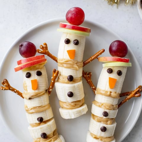 Banana Peanut Butter Snowmen are adorable—banana snowmen with chocolate chip eyes and festive candy noses!