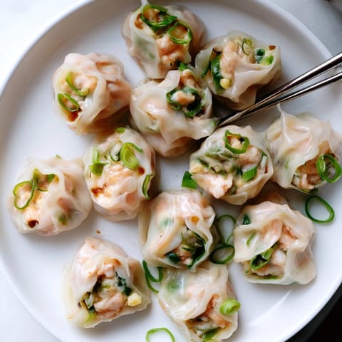 Homemade Cheesy Shrimp Scallion Dumplings in a bamboo steamer, promising a delicious Asian-fusion appetizer.