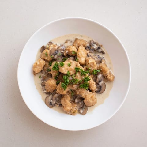A pan of Creamy Chicken Stroganoff, with a creamy, mushroom-infused sauce and fresh parsley.