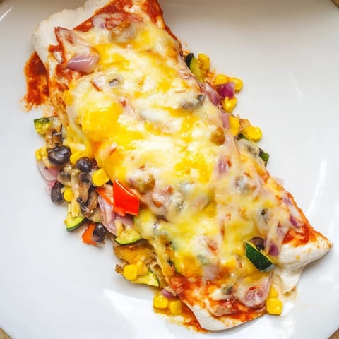 Golden, cheesy Farmers Market Vegetarian Enchiladas, fresh from the oven, with a side of sliced avocado offered.
