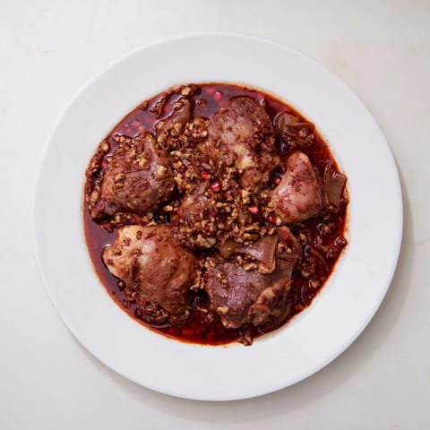 Savory Budget Fesenjan Stew features juicy chicken in a rich, walnut-pomegranate molasses sauce, served hot.