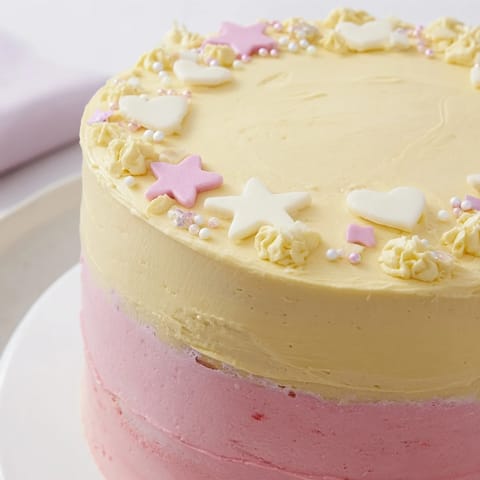 This delightful Château de Princesse Cœurs et Étoiles cake, a layered dessert ready for celebration, is adorned with edible stars.