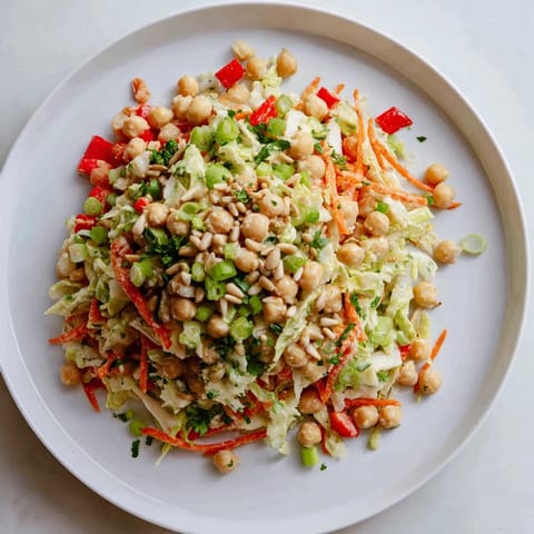 Imagine the Fiber-Forward Chickpea Salad: a delicious bowl of chickpeas and chopped vegetables, drizzled with lemon dressing.