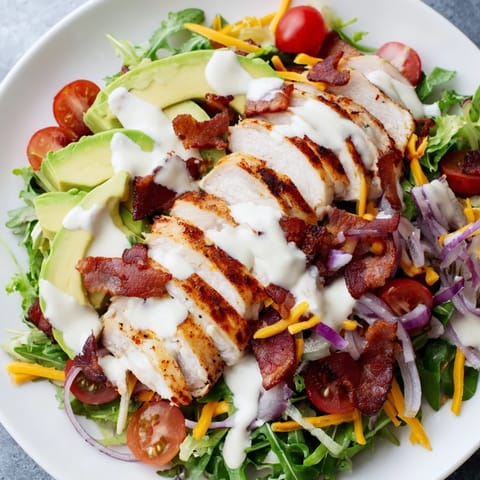 Fresh and flavorful Crispy Bacon Chicken Salad, featuring ripe avocado, tomatoes, and tender chicken, ready to eat.