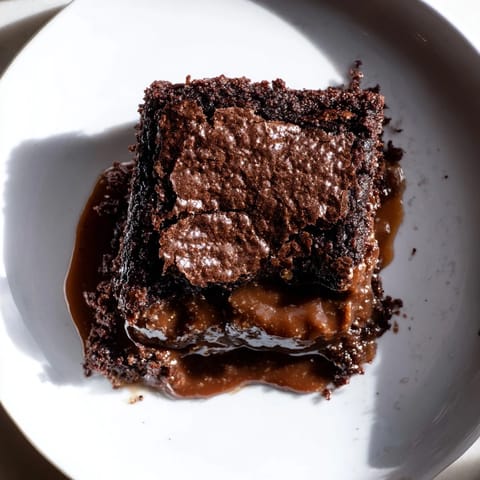 Enjoy this comforting Ina Garten Brownie Pudding: A fudgy, homemade dessert served with vanilla ice cream.
