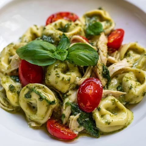 This Creamy Pesto Tortellini Skillet features golden, cheesy tortellini coated in a lush basil pesto cream sauce, studded with juicy chicken and bright cherry tomatoes.  