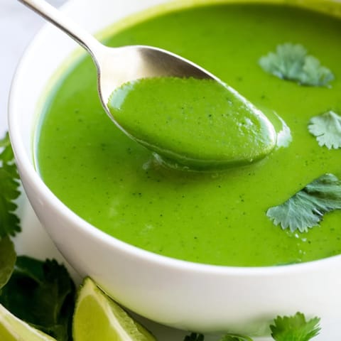 A steaming bowl of Spinach Coriander Lemongrass Soup, perfectly garnished with cilantro.