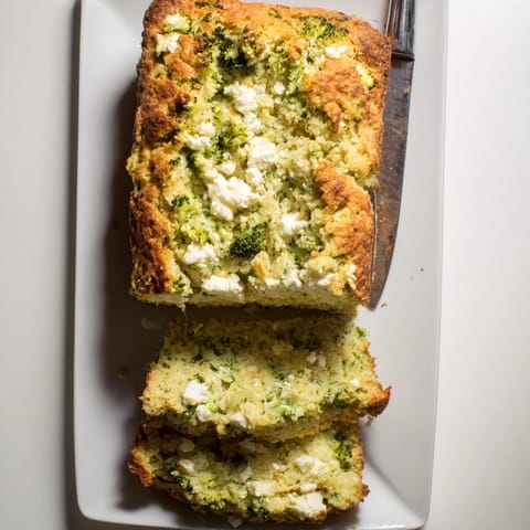 Freshly baked Broccoli and Feta Loaf, featuring tender broccoli and tangy feta, served warm with a side of tomato soup.  