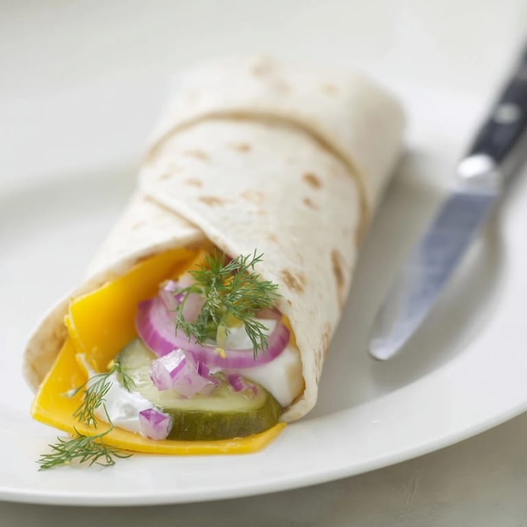 Savory pickle-in-a-blanket treat, rolled with cheese for easy party sharing.