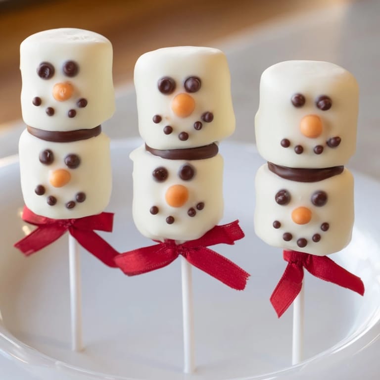 Festive Express Snowman Marshmallow Pops: a close-up of cheerful, decorated holiday dessert on a stick.
