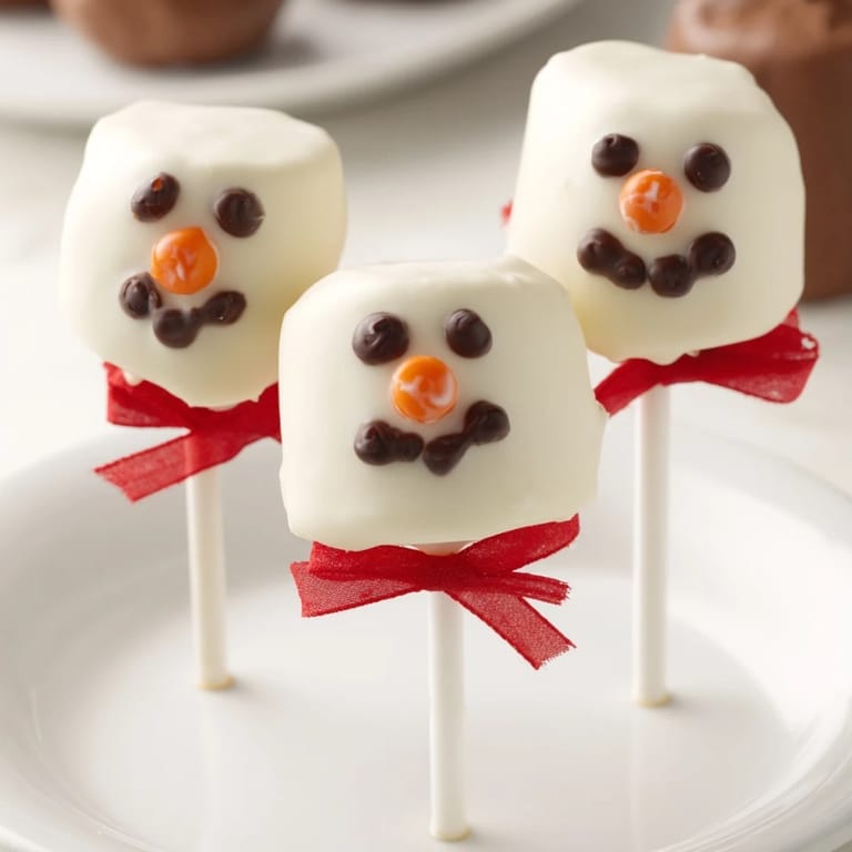Sweet, melt-in-your-mouth Express Snowman Marshmallow Pops, a delicious winter dessert easily made at home.