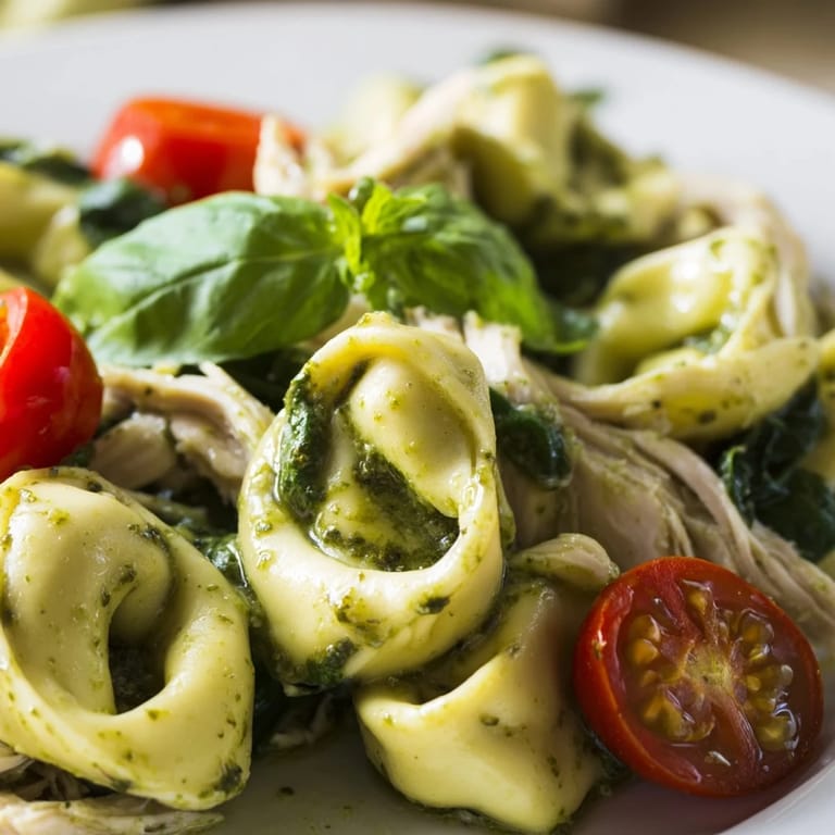 Hearty bowl of Creamy Pesto Tortellini Skillet with tender cheese tortellini, rotisserie chicken, and wilted spinach in a creamy, herbaceous pesto sauce.