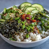 A vibrant Seaweed & Nori Rice Bowl with seasoned sushi rice, crisp cucumber, and toasted sesame seeds for an umami-rich vegetarian meal.  